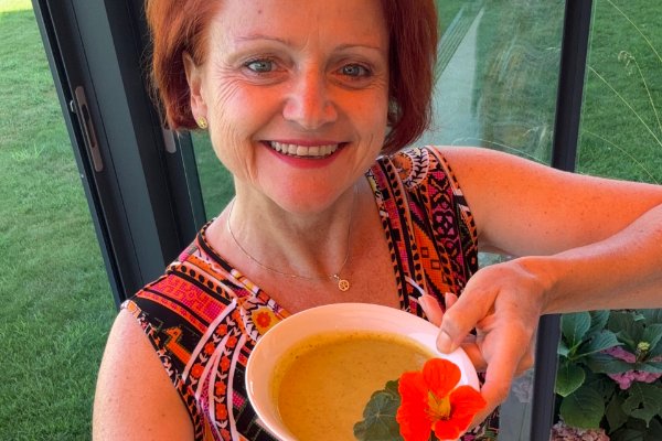 Manuela mit einer Schale lauwarmer Gurkensuppe, garniert mit Kapuzinerkresse